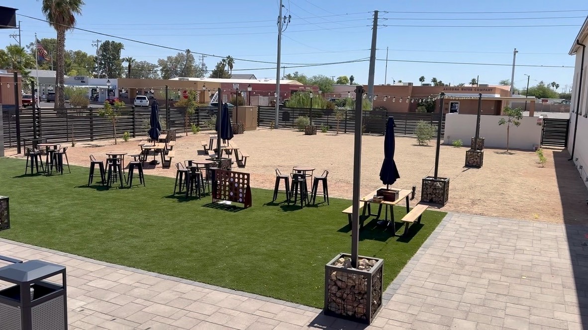 Terminal 318 lawn area with bar tables, stools, and string lights